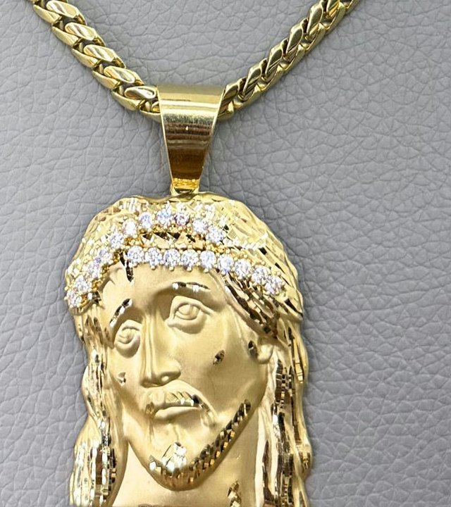 Dije de oro 14k con cadena sobre un exhibidor